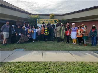 picture of staff dressed for halloween in front of school